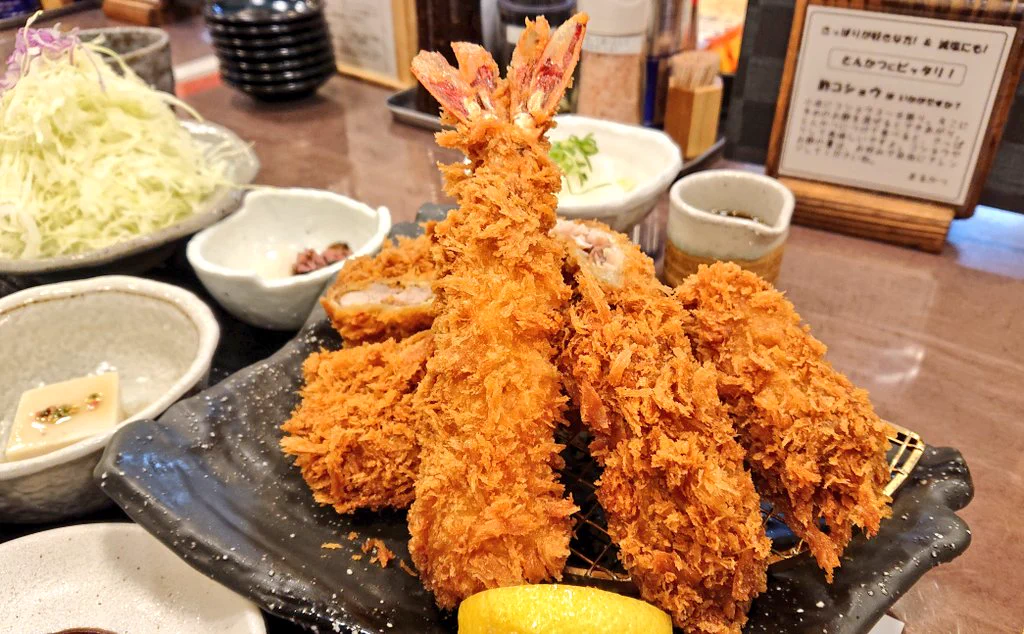 スペースの有効活用？とんかつ屋さんの店長。何故か背中に張り紙をしてお仕事中。
