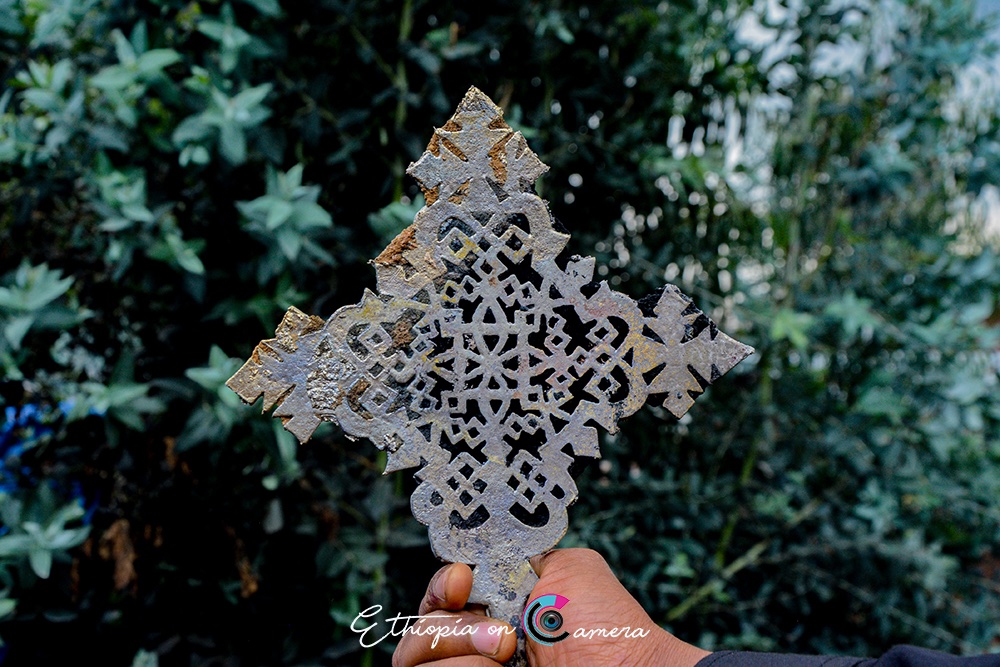 5/5 Liquid metal is poured into the empty mold and left to cool and harden. Later, the clay exterior is broken open, revealing the finished cross beneath.Once it has cooled down, the cross is first filed smooth and its frame are further ornamented with incised lines.