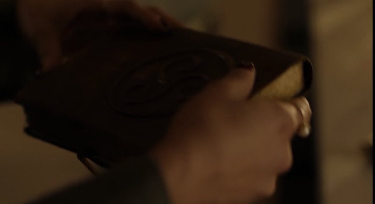 now what really kicked off this theory is something i noticed on abigael’s book. here we see two books, (2x11 vs 2x14) which might be the same books, but either way they bear the same symbol: a triskele, which is a celtic knot of three.