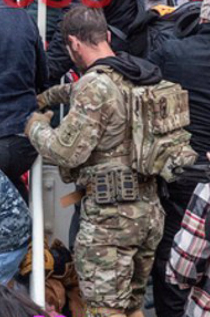 Magnolia has slick military kit. He appears to be wearing a black hoodie under camo & has a magnolia patch and two Punisher patches. One is where his rank would be, so it’s likely he is not current or former military. A soldier is not likely to do that.