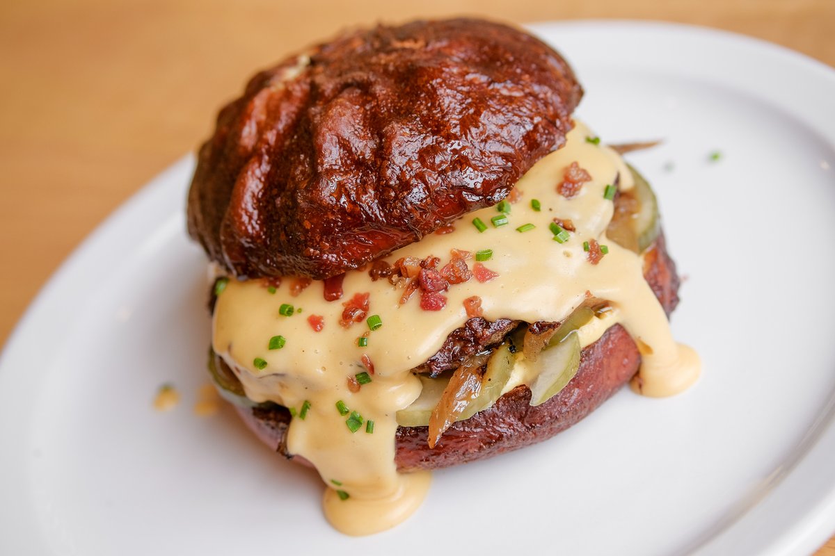 Saturday Special: The PAMP Pub Burger made with a PAMPtisserie pretzel bun, dijon mustard, butter pickles, caramelized onions, dopplebock beer cheese, bacon bits, and chives. 🤤 Get it today only 1/23: toasttab.com/pamp