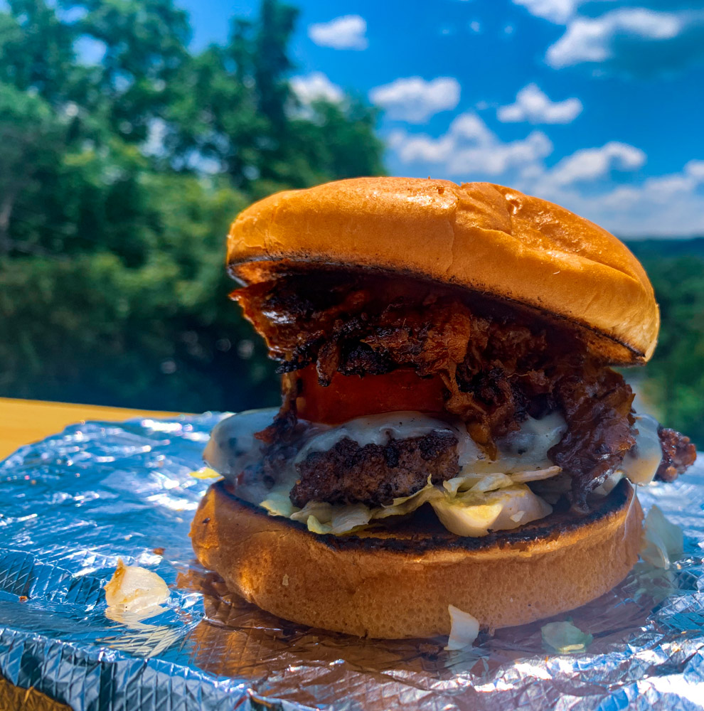 We are dreaming of sunnier days in Morgantown 💭 Come warm up with a Backyard Smash Burger, piled high with all of your favorite toppings. Open all weekend from 11am-8pm!  #BackyardCheatLake