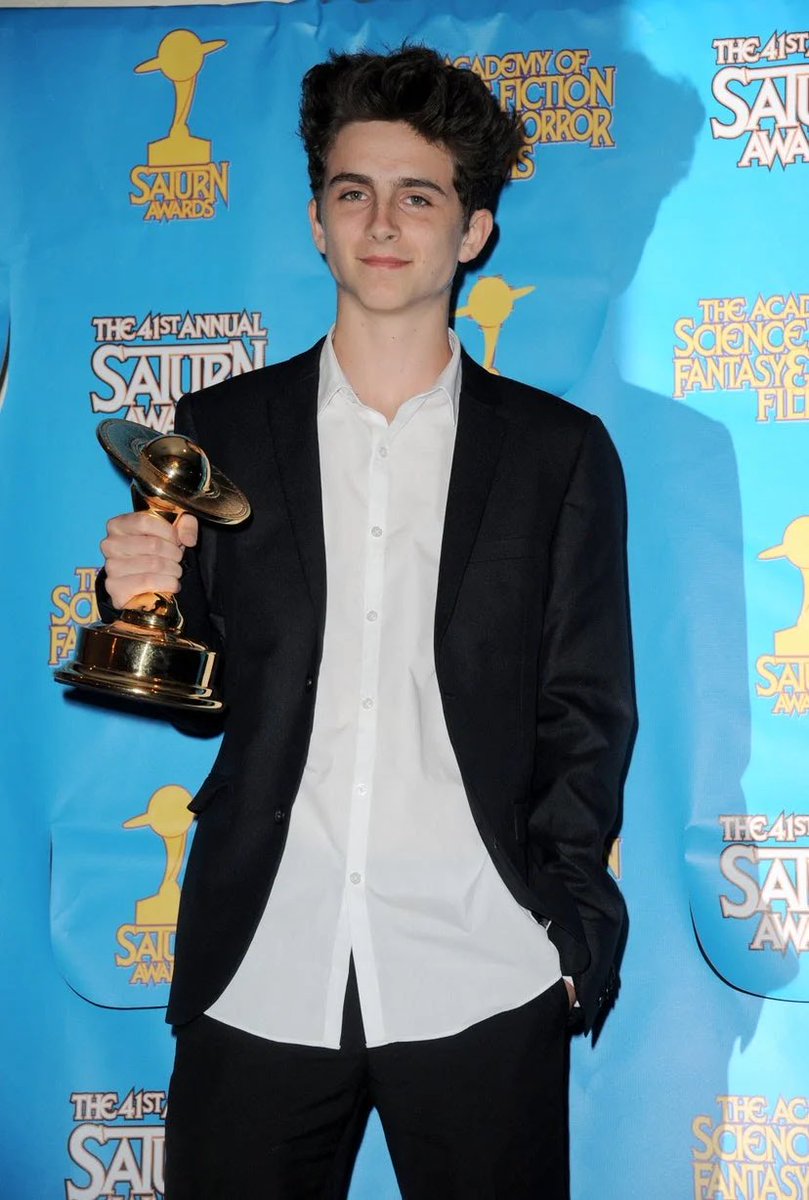 25 June 2015The actor collected a Saturn Award on behalf of Hans Zimmer wearing a black suit and a white (untucked) shirt.Timothée posed with Kiernan Shipka at a summer party wearing a burgundy knit jumper and camel desert boots.
