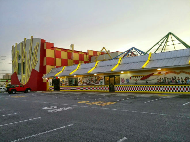 this location's original incarnation was visible from a distance, thanks to its bold checkerboard paintjob and two-story neon french fries. before entering, guests would be treated to colorful, unusual murals, declaring this location "the most unique mcdonald's in the world".