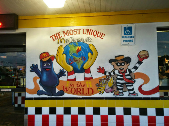 this location's original incarnation was visible from a distance, thanks to its bold checkerboard paintjob and two-story neon french fries. before entering, guests would be treated to colorful, unusual murals, declaring this location "the most unique mcdonald's in the world".