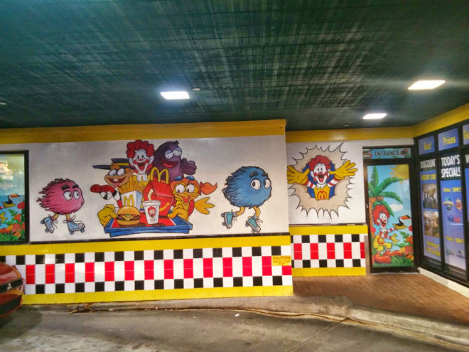 this location's original incarnation was visible from a distance, thanks to its bold checkerboard paintjob and two-story neon french fries. before entering, guests would be treated to colorful, unusual murals, declaring this location "the most unique mcdonald's in the world".