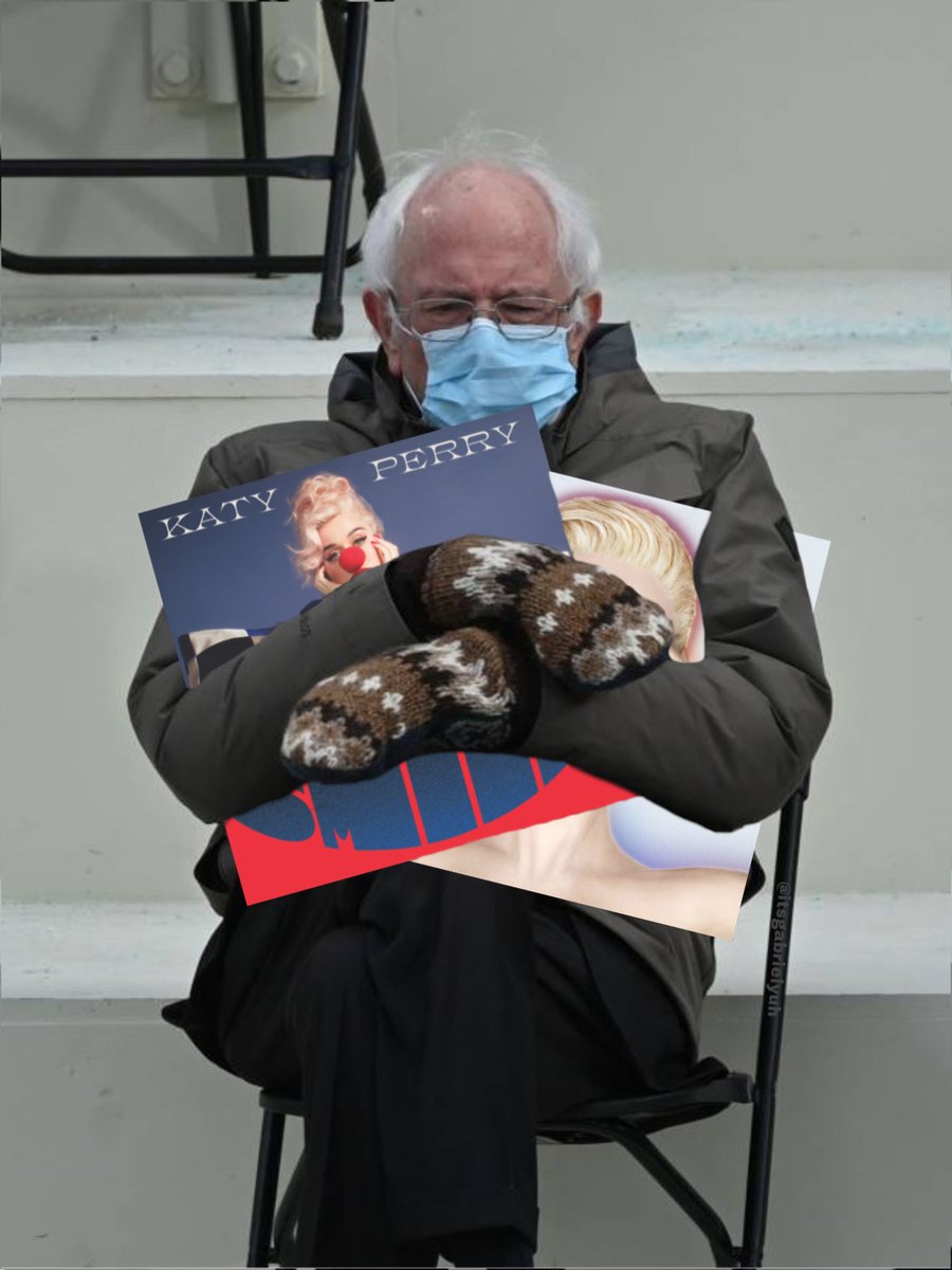 Bernie Sanders Holding Two Katy Perry Albums (To The Left Is Her Album “Smile”, To The Right Is Her Album “Witness”)