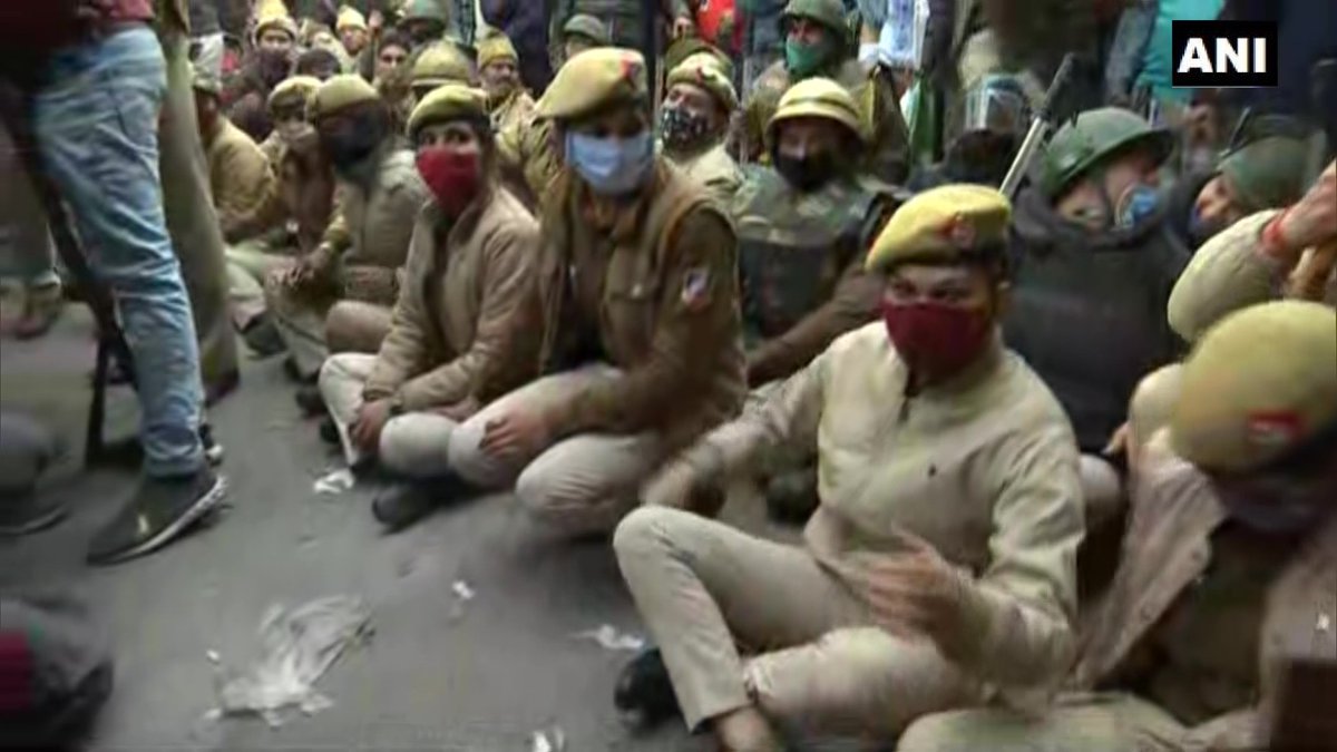 ANI's tweet photo. Delhi: Police officials sit on road in Nangloi to block the area where farmers holding tractor parade have reached https://t.co/Rjiz26K4dk