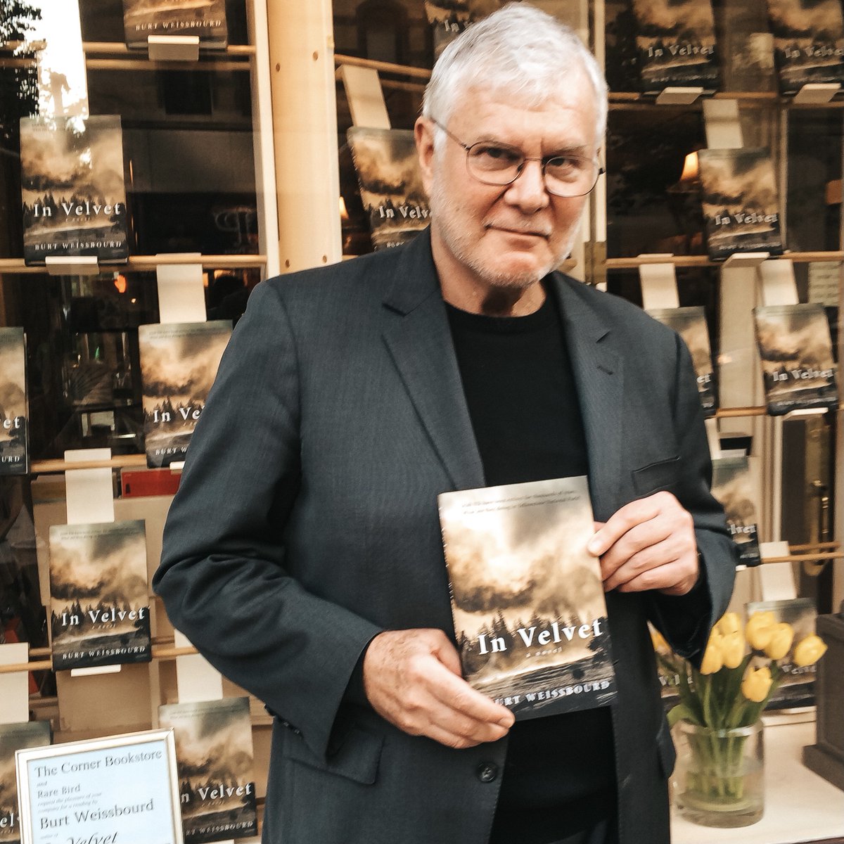 Man holding In Velvet book outside of The Corner Bookstore in NYC.