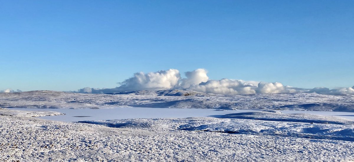 A milky frozen loch (Voxterby mebbe) and snow clouds, looking north
