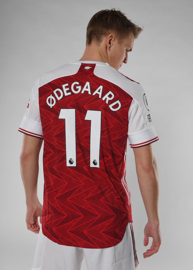 Martin Odegaard poses with his back to the camera to show his Odegaard 11 shirt