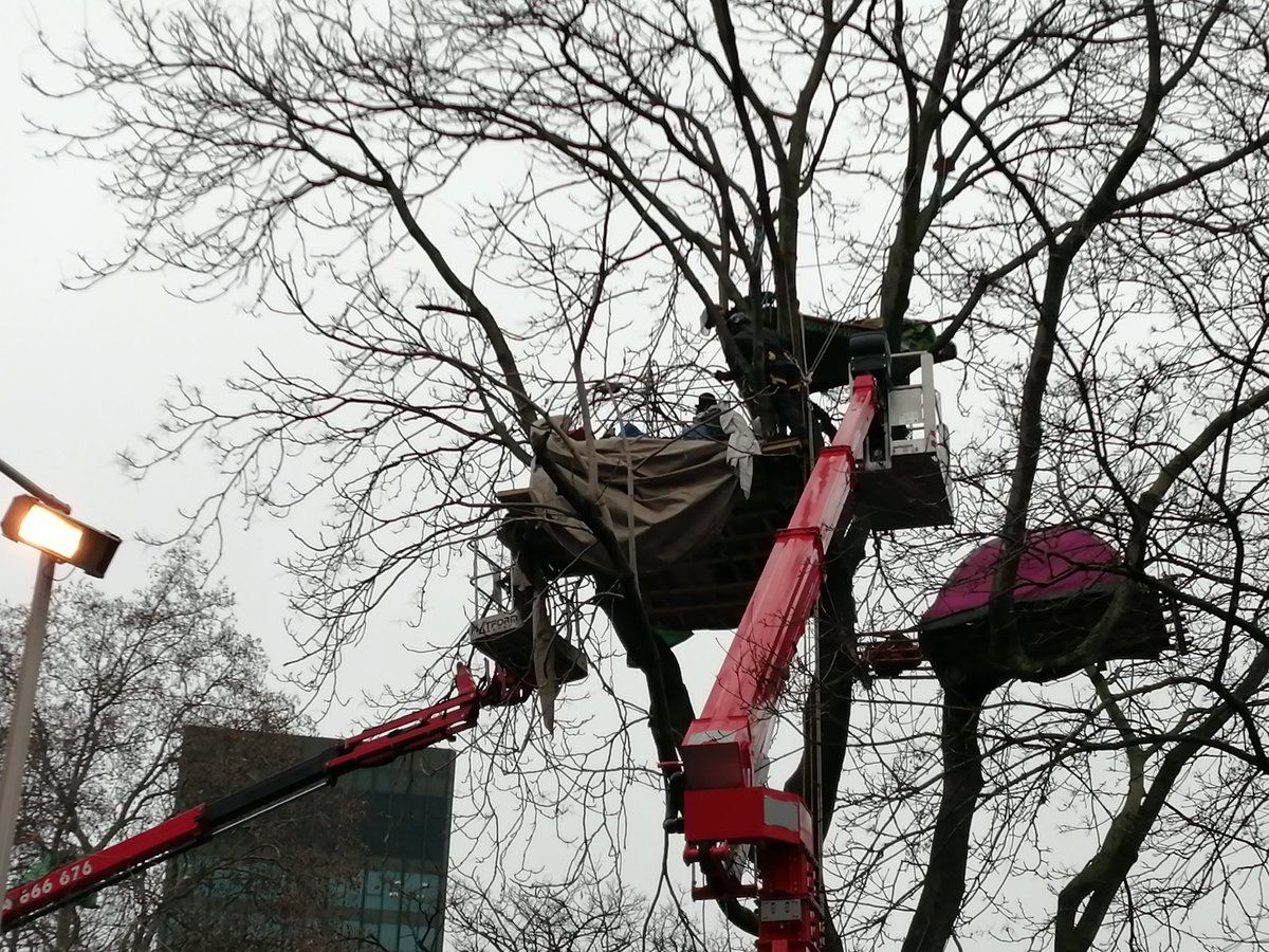 The covering of the structure has now been removed.Protesters seem to be lying down.
