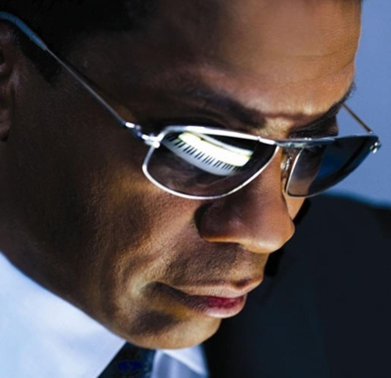 Herbie Hancock with a piano reflected in his sunglasses.