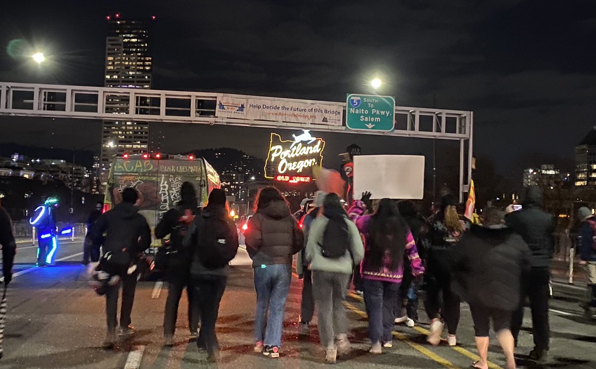 As protesters continue across the bridge, they pass under a sign. The sign reads “help decide the future of this bridge.”while it is not inherently related to this protest, something about the imagery there just feels very beautiful to me.
