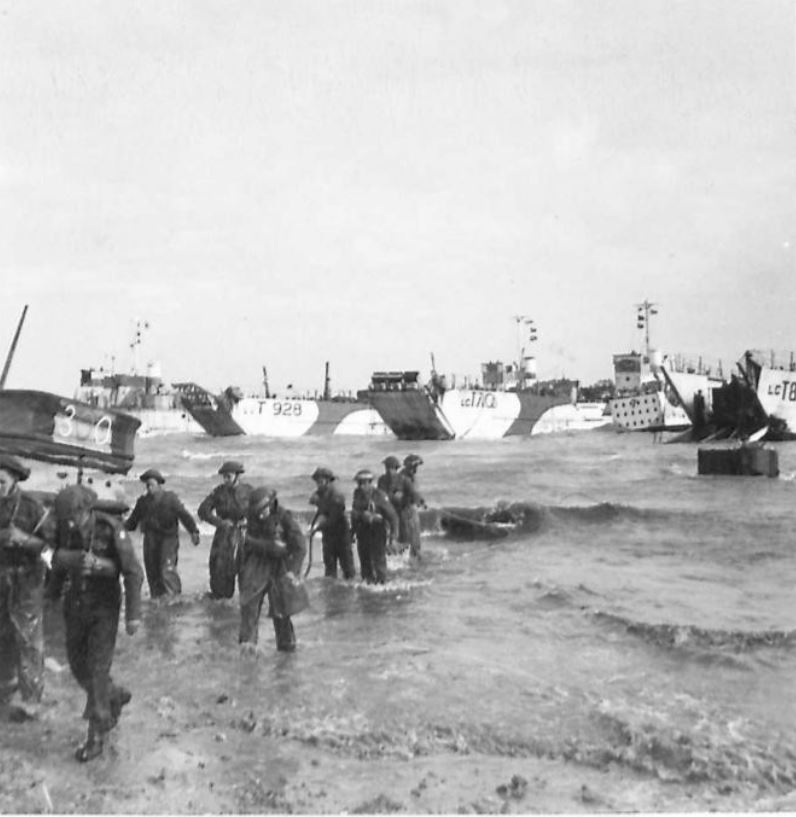 His first photo shows chaos on Jig Beach. On the right is LCT 858, 33 LCT Flotilla, possibly one of those in the aerial photo, having broken through the obstacles and finishing disembarkation. On the left is a DD, possibly one from the LCT Mk III we saw earlier. IWM B5243