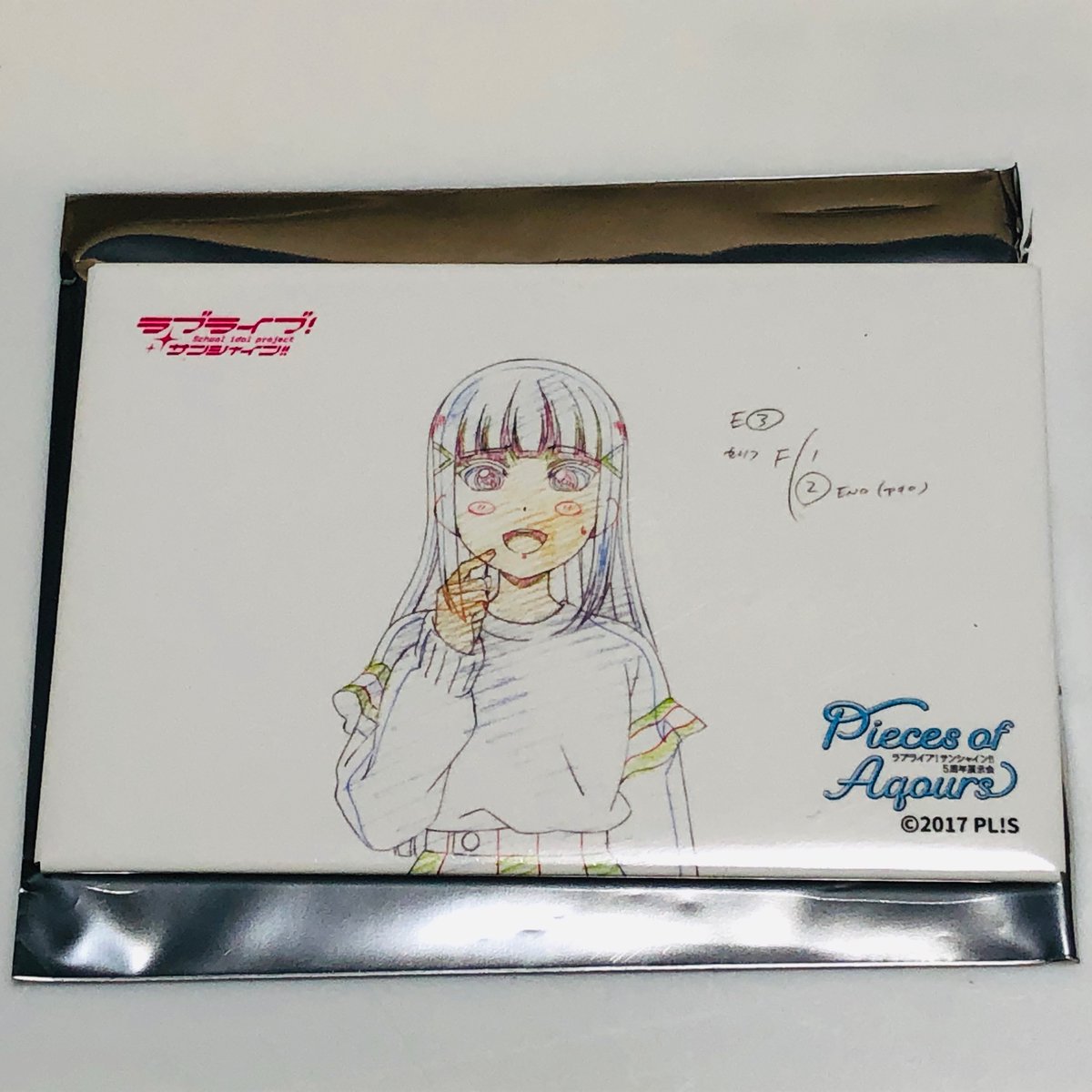 先日、Aqours5周年通販の原画集と缶バッジ届いてました。
ランダムバッジはダイヤちゃん?
原画集、表紙のロゴ、ホロ加工や! 