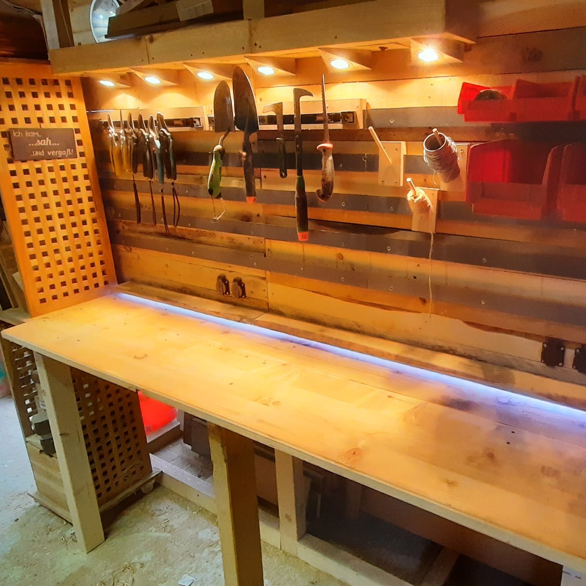 Upcycling Werkbank. Verwendete Materialien: Palettenholz, Biertisch, altes Regal, alte Lampen, LED Streifen Reste. Gesamtkosten: 11€ für die Steckdosen und ein paar Schrauben.