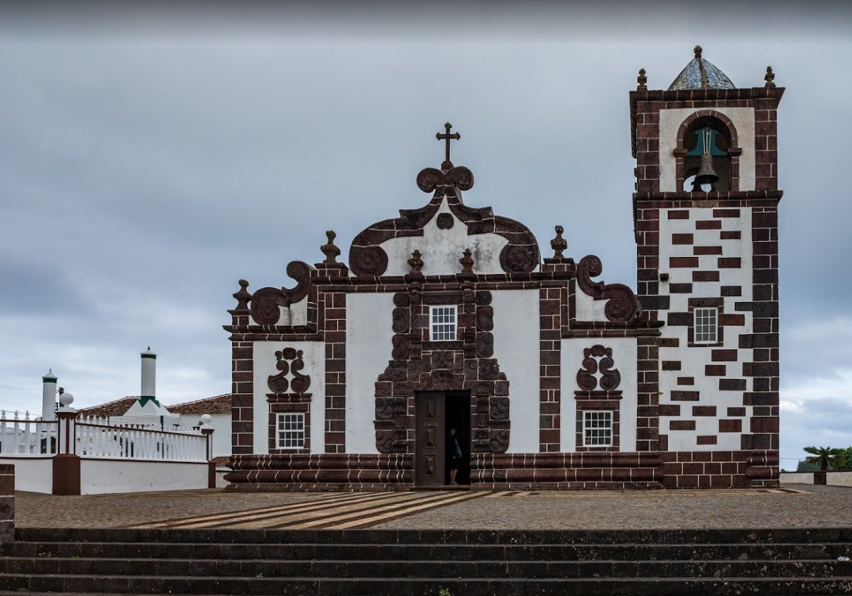  The chosen church in Santa Maria is Nossa Senhora da Purificação in the hamlet of Santo Espírito (pop. 588). It’s almost like something out of Hansel & Gretel, with a chessboard pattern on the belltower and a really elaborate basalt frontispiece.