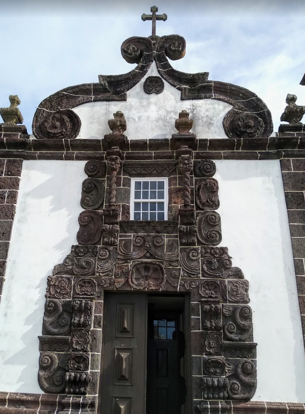  The chosen church in Santa Maria is Nossa Senhora da Purificação in the hamlet of Santo Espírito (pop. 588). It’s almost like something out of Hansel & Gretel, with a chessboard pattern on the belltower and a really elaborate basalt frontispiece.