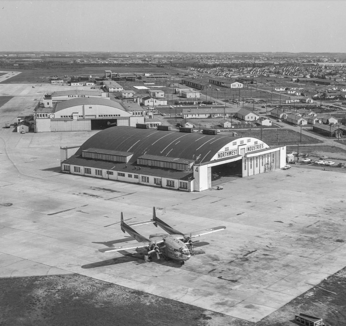 View looking north toward the former U.S. Army Air Force hangars. Hangar 11 (with the no. 3) is second from the front. "Northwest Industries" (aircraft repair) would also occupy Hangar 11 during the WWII effort. • 1958 (RP303.1)