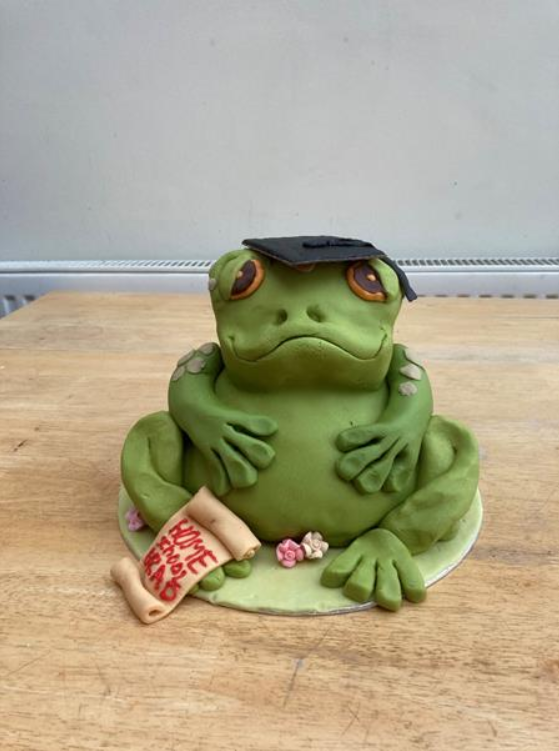 teddingtonschl's tweet photo. Here is the winner! Lucy in year 8 has created a masterpiece! Titled, “The frog who’s graduated from homeschool”. Huge congrats to Lucy! #teddington #bakeoffwinner #interhouse #youngbakers #juniorbakeoff https://t.co/tXGGHQfD1Q