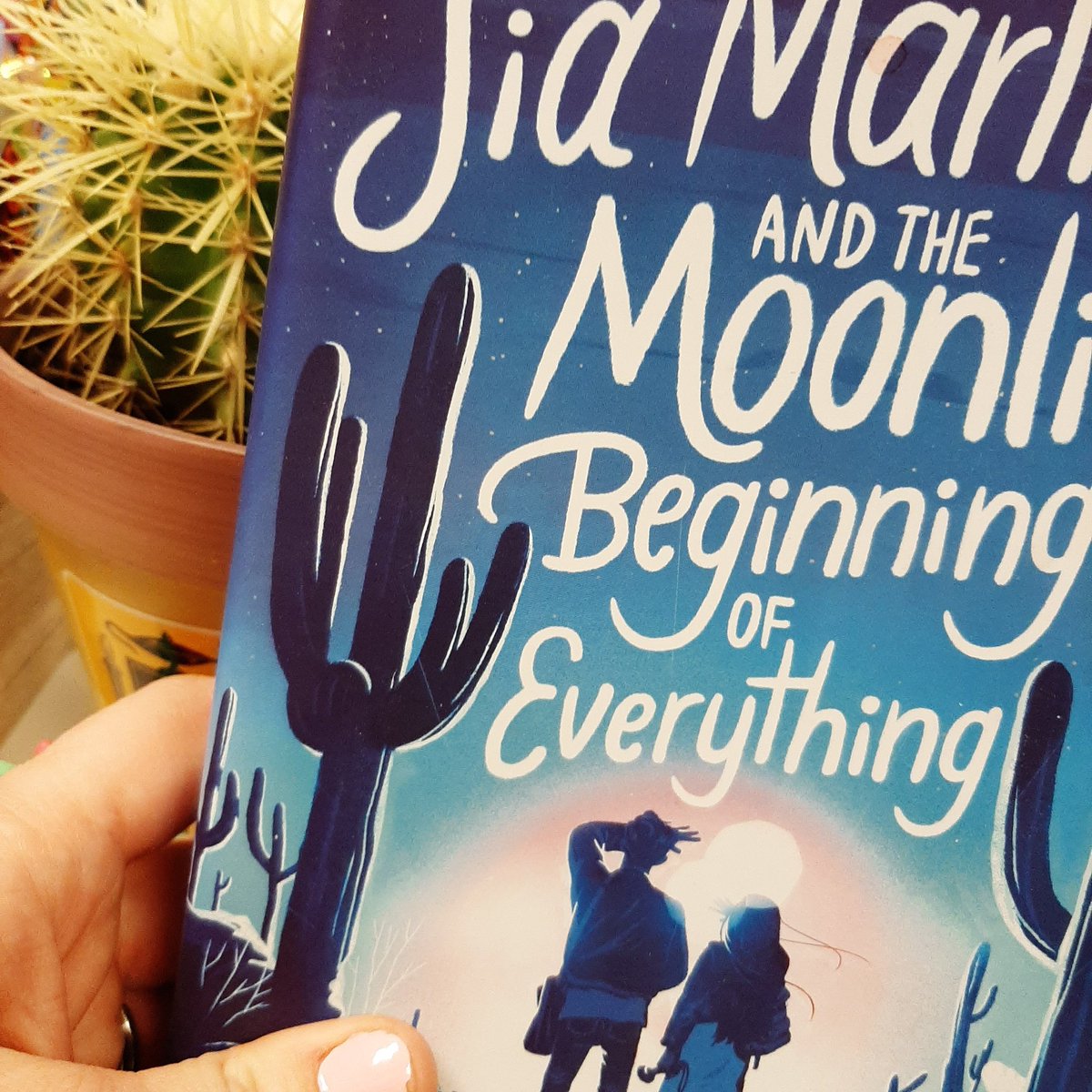 drbtlibrary's tweet photo. Had to capture this with my #cactus. So #siamartinezandthemoonlitbeginningofeverything is a fast paced book about love family ghosts aliens immigration bullying abuse sex friendship and probably a bunch of other things. So good I could not put down. @raquelvasquezgilliland_poet https://t.co/tPaLLif2i4