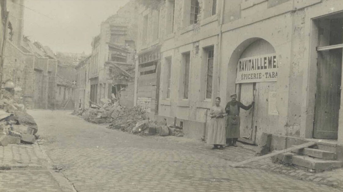 Shopkeepers stand amid the ruins of the village of Cormicy, in the Marne department, in 1915.