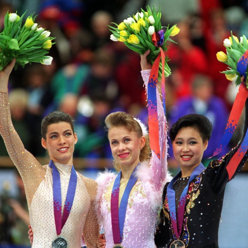 1998: michelle kwan wins the silver medal in nagano with her sleek velvet costume with tank-top straps ushers in a new era of more skintight, athletic costumes compared to the heavier and elaborate dress costumes as seen below on the 1994 olympic podium