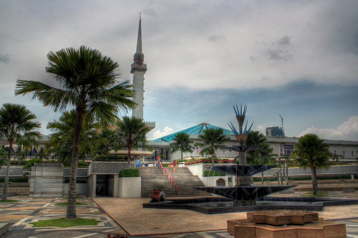 Tonight's site is the National Mosque of Malaysia in Kuala Lumpur. It's located in 13 acres of gardens & has a 240 ft tall minaret. It was first opened in 1965, then underwent renovations in 1987 which included having the original pink concrete roof clad in green & blue tiles.