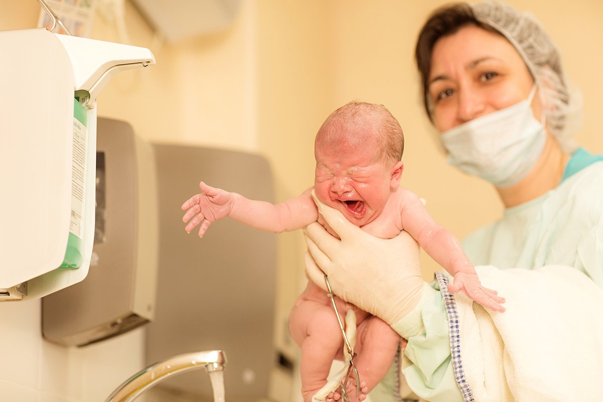 Акушерки принимающие роды. Акушерка с новорожденным. Медицинская сестра и новорожденный. Младенец на руках у акушерки.