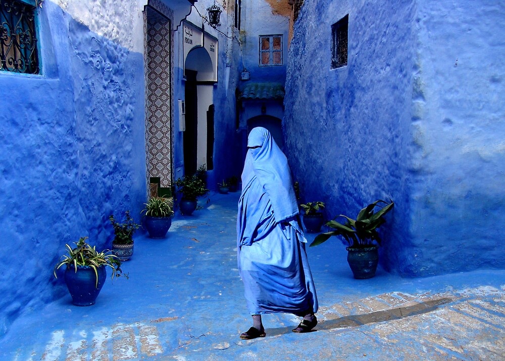 People walking in Chefchaouen alleys.