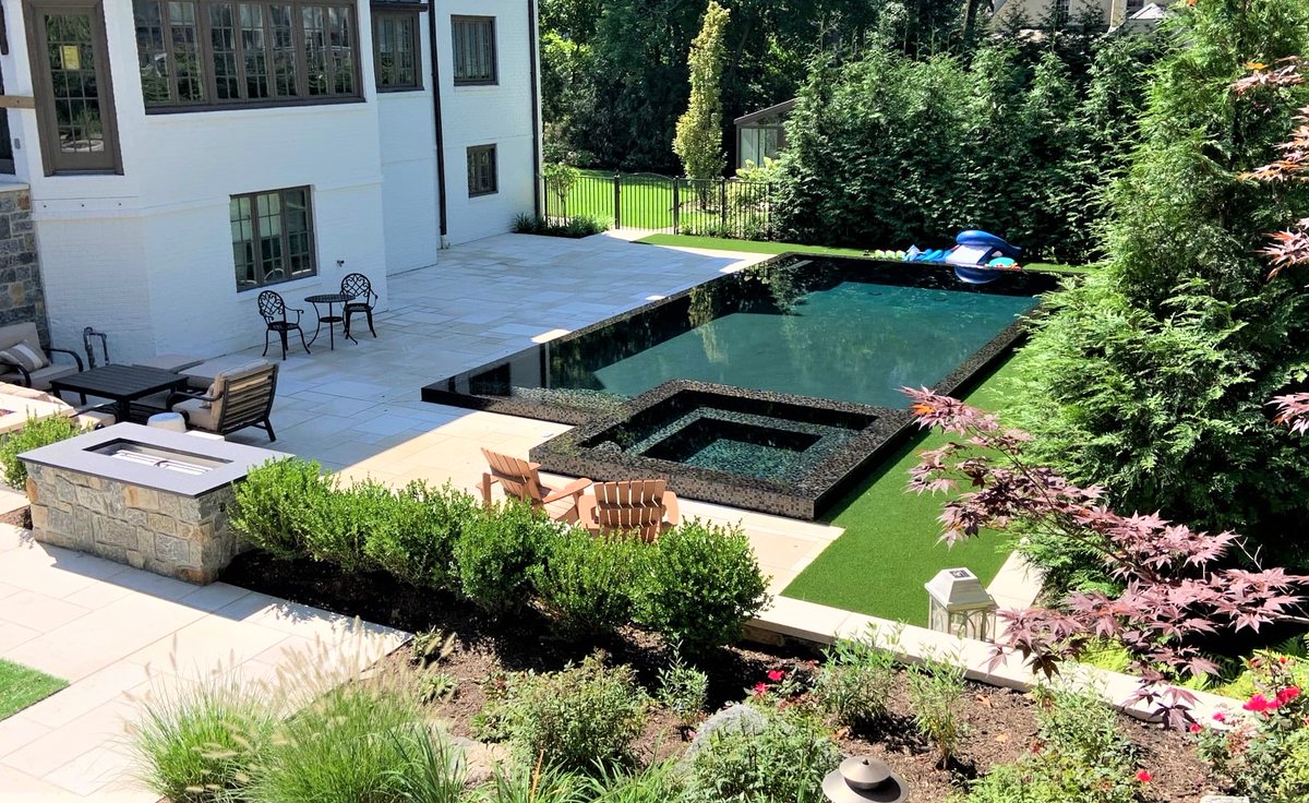 Forget the #snow and #picturethis for #summer2021! This #contemporary #backyardoasis in #ridgewoodnj features a perimeter overflow #pool with #glasstile, #outdoorkitchen, #masonrywalls &amp; #patios and a modern layout for #plantings! #wedoitall! #OneCallAway 201-785-0800 #staycation