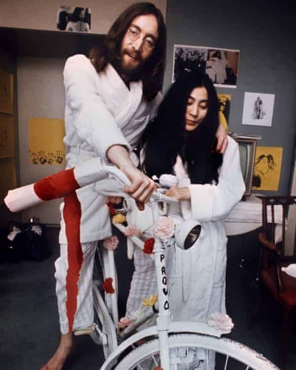 John Lennon and Yoko Ono with a bike.