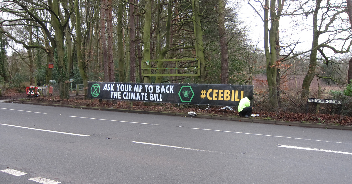 WokingXr's tweet photo. In case you hadn't heard about the #Climate &amp; Ecological Emergency Bill, we're putting this banner up around #Woking. Have you seen it yet? If you care about our #PerfectPlanet ask our M.P. @JonathanLord to support the #CEEbill https://t.co/I1EvQ1WApD https://t.co/8Ohzyg7JTQ