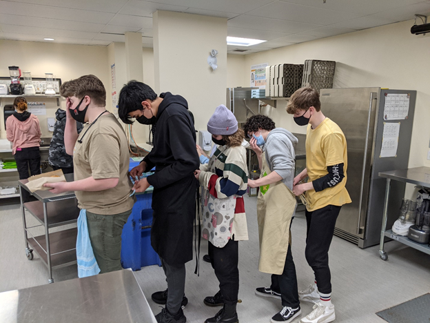 SurreyChristian's tweet photo. Food 12 students helping each other out with tying on their aprons. #scsSecondary #scsFoodsLab #scsGrad21 https://t.co/AudthHuW4F