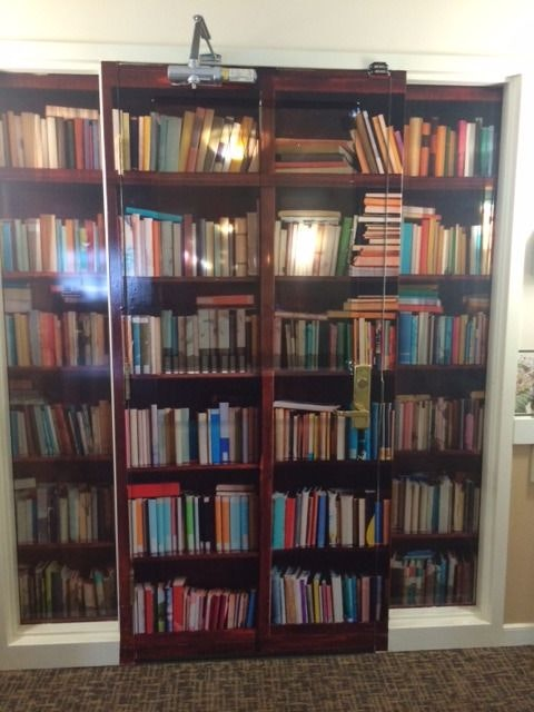 Meanwhile the actual exit from the abusive system is kept carefully hidden. A lot of dementia care facilities will disguise their exits by painting them to look like murals or bookshelves, like this: