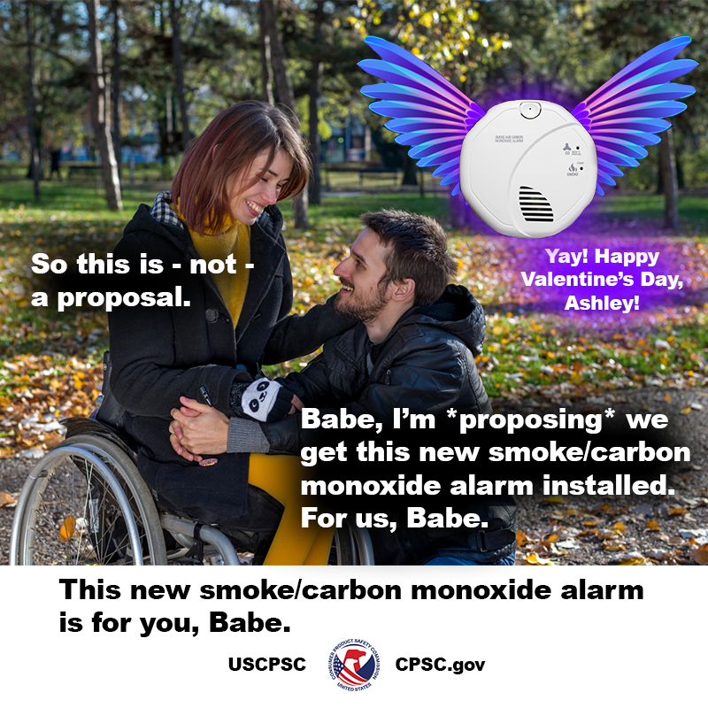 A woman in a wheelchair out on a walk through a park with her significant other. He is kneeling next to her. There is a smoke/carbon monoxide alarm with purple wings flying next to them. The woman says, "So this is not a proposal." He replies, "Babe, I'm proposing we get this new smoke/carbon monoxide alarm installed. For us, Babe." The smoke/carbon monoxide alarm says, "Yay! Happy Valentine's Day, Ashley!" The text reads: This new smoke/carbon monoxide alarm is for you, Babe.