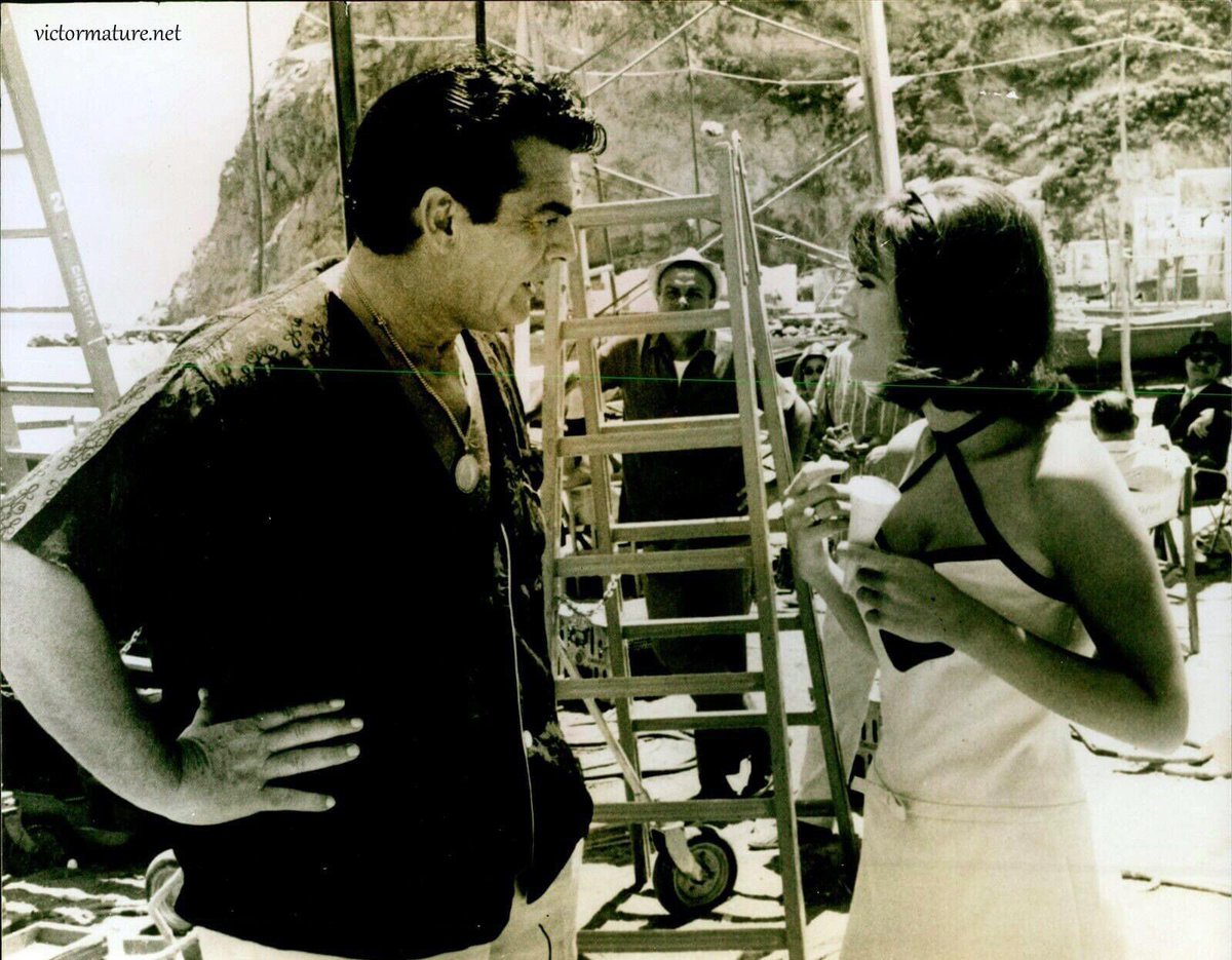 #VictorMature chats with #BrittEkland, on location in a fishing village on Italy's Isle of Ischia while filming the #NeilSimon / #VittorioDeSica comedy #AfterTheFox (1966) ...also co-starring the great #PeterSellers ... @vic_pratt @PeterFandom @BrittEkland @VictorMatureNet
