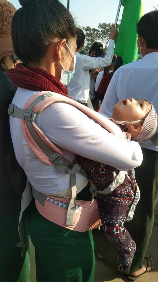 The teacher brings her infant with baby wrap to show her demonstration opposes military coup. 
Courtesy : photo by myintzu ko ko