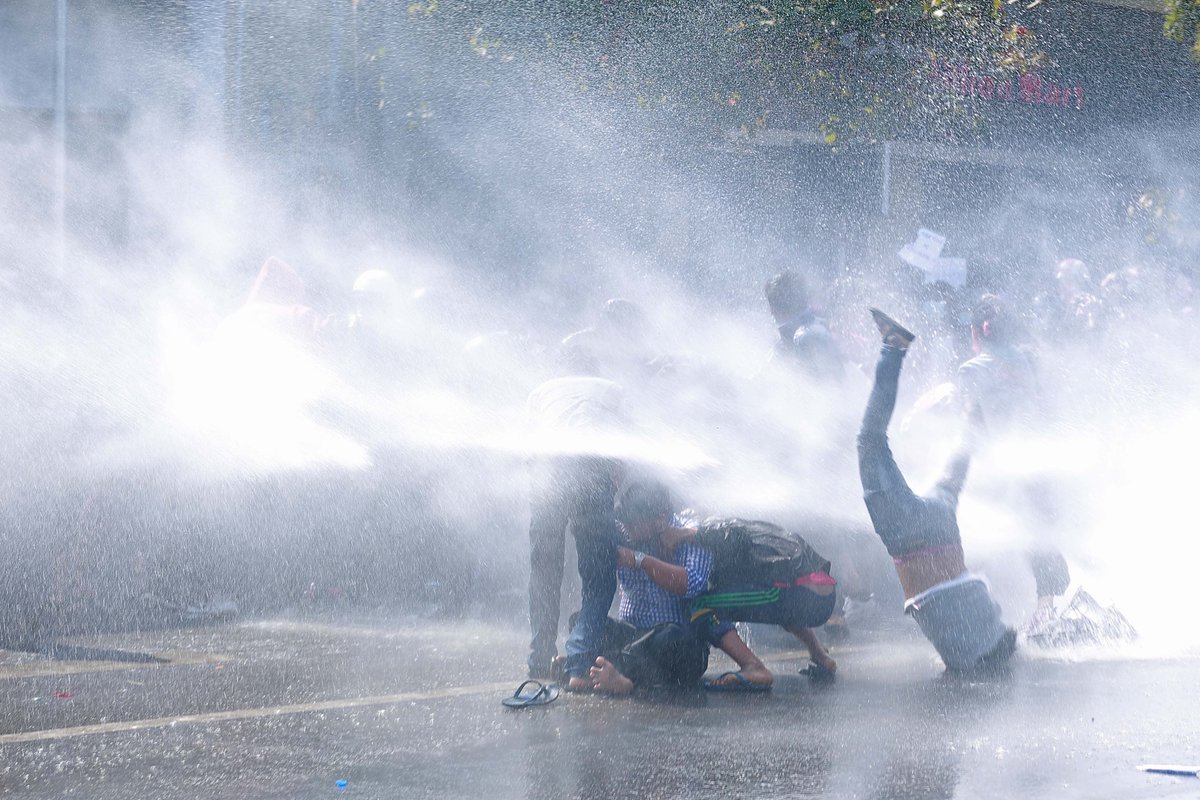FrontierMM's tweet photo. Dramatic photos from Mandalay show the impact of water cannons on protesters. Police have also used water cannons in NPT, injuring several people, and have some stationed at Hledan in Yangon. #WhatsHappeningInMyanmar 
See more photos on our liveblog: https://t.co/3I5sZ5Pxb4 https://t.co/SaObOdZxjc