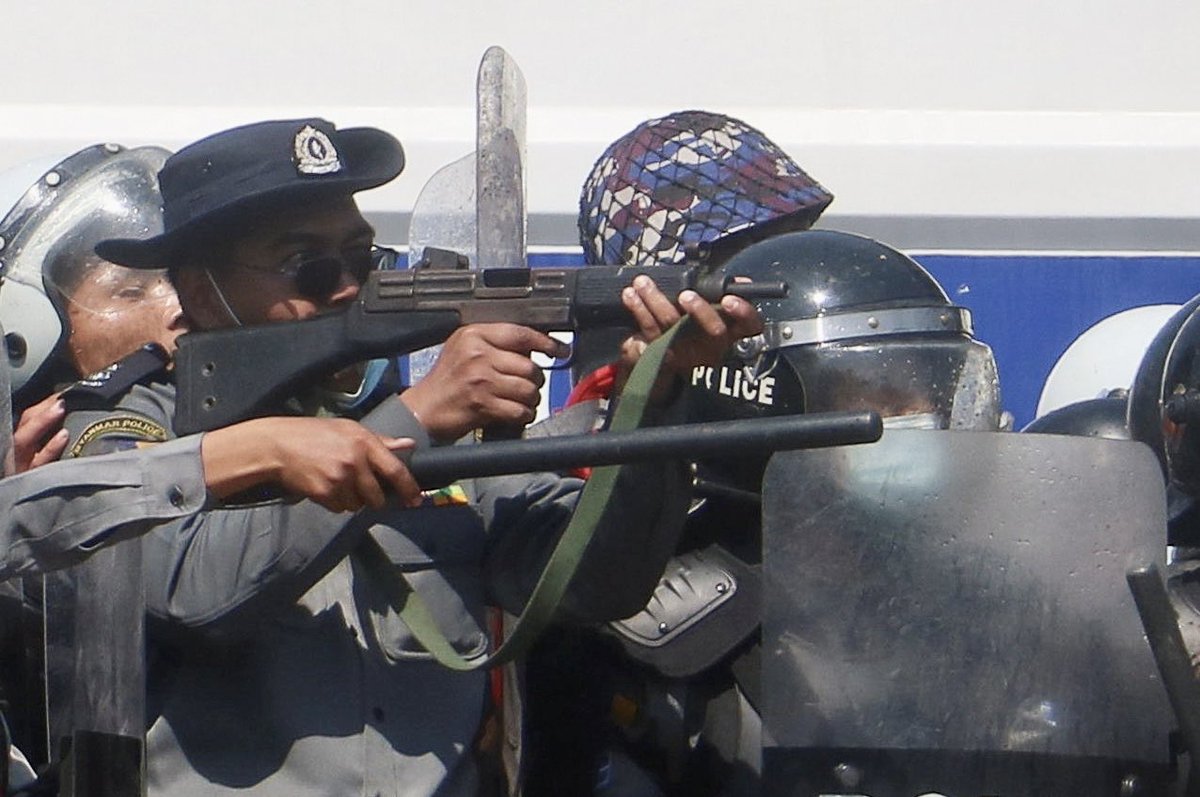 Myanmar police officer points gun towards protesters in Naypyitaw. One woman was not expected to survive after being shot, a doctor said. #WhatsHappeningInMyanmar
