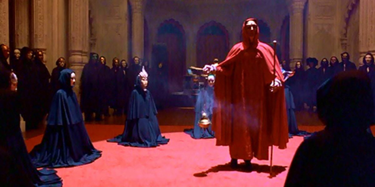 26\\The high priest of the ceremony, wearing a red cloak, speaks with a British accent.