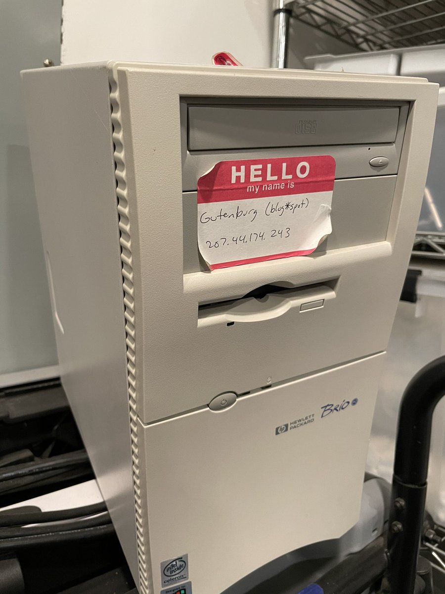 Blogspot’s original server machine, a beige tower style PC from the late 1990s with a Hello My Name is nametage with blog*spot and Gutenburg written on it.