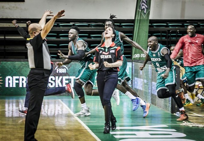 L'arbitre lève les bras pour terminer le match, tandis que les joueurs et la coach sautent de joie.