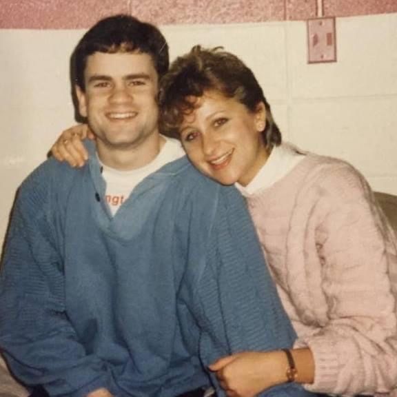 A 1980s snapshot of a man and woman posing with the woman's arm around the man's shoulders