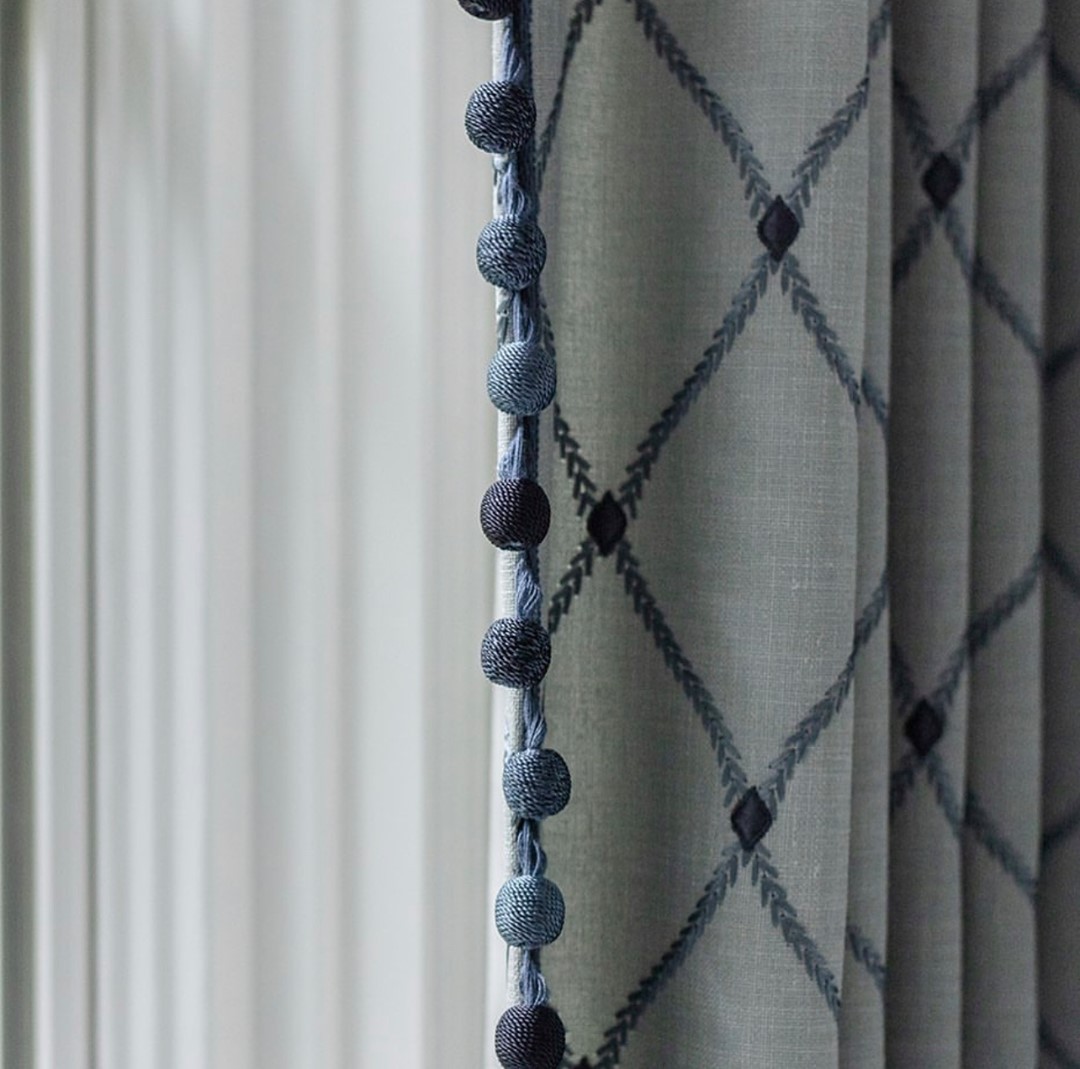 Subtle shifts from light to dark, shades of blue are captured in drapery details from Courtney Hanig Interiors. On the leading edge: Céline Ombré Ball Fringe in Ink: bit.ly/3u0Ni7e