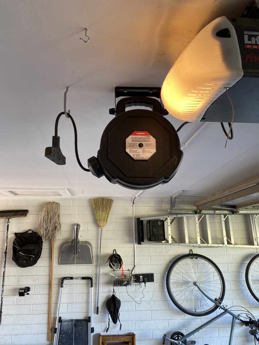 In the center of the ceiling, I have this retractible cord reel. Insanely handy. Stretches out to the driveway easily when I am using the tablesaw or some other tool out there. A ceiling hook to hold the loose end keeps it out of the way. I have another of these in the backyard.