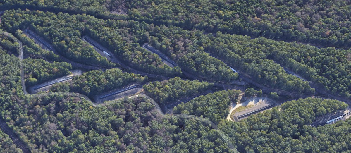 These leaf-like sidings look odd from the air, and notably are located far away from the rest of the site. Why? Well, it's to store excess munitions before they can be properly stored in bunkers or warehouse facilities. Zoom in and you'll find something special about them...