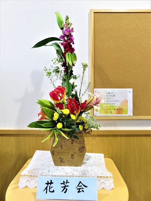 駒込地域文化創造館 展示情報 今週の花 芳会さんの作品です 八重ユリ キンギョ草 コワニー ワックスフラワー グロリオサ レースフラワー スプレー菊 カリメロ ヤシ皮と8つの花材が使われています バレンタインデーも過ぎ 段々と暖かく 日没も