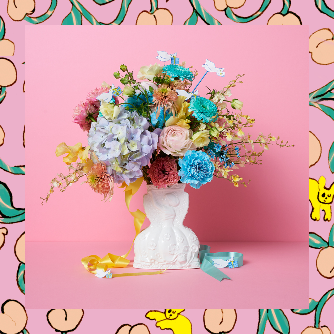 Afternoon Tea イラストレーター北澤平祐氏のアイテムが今年も登場 花を生ける と女の子が花束を持ち上げているように見えるデザインの花瓶と グラスやペットボトルにかぶせて使う紙製のフラワーベースカバー アートを施した上品な花瓶に花を飾れば